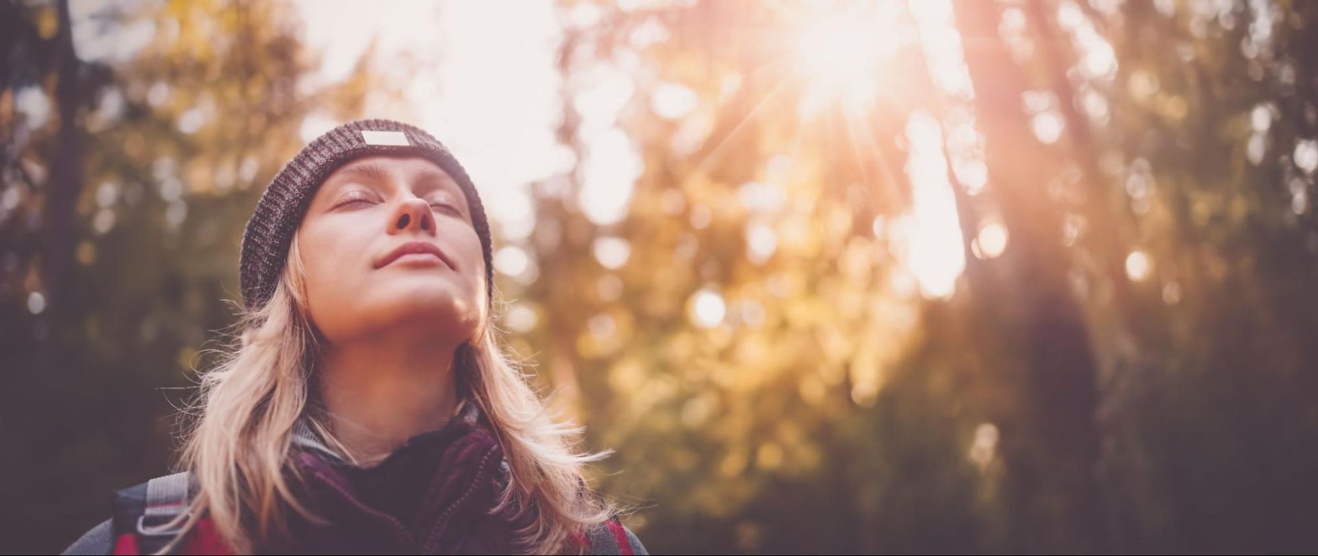 picture of a woman in the woods, feeling good and smiling after taking CBD for headaches